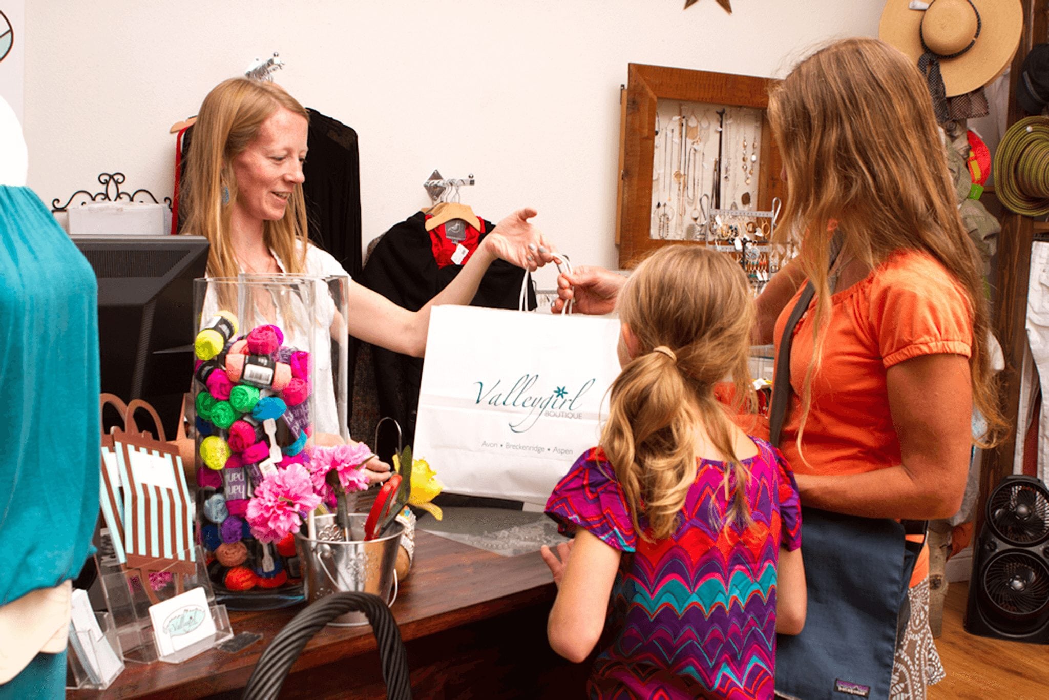 A mother and daughter checking out while shopping.