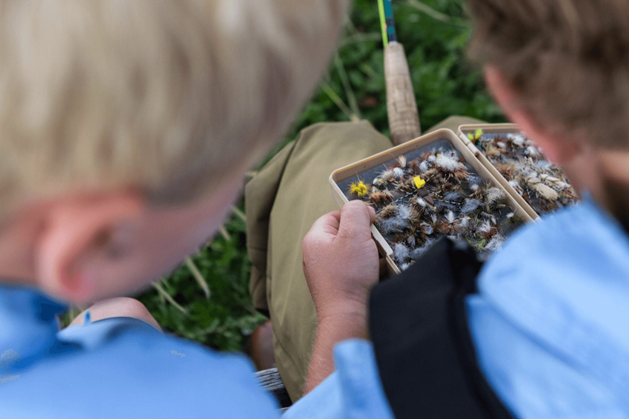 The father looking through the tackle box while fly fishing in Colorado