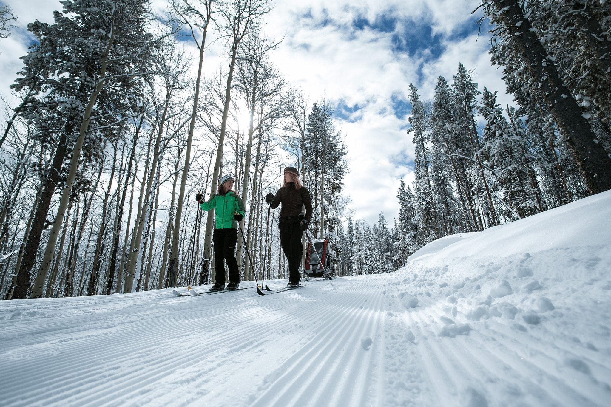 A family cross country skiis with a trailer in Breckenridge.