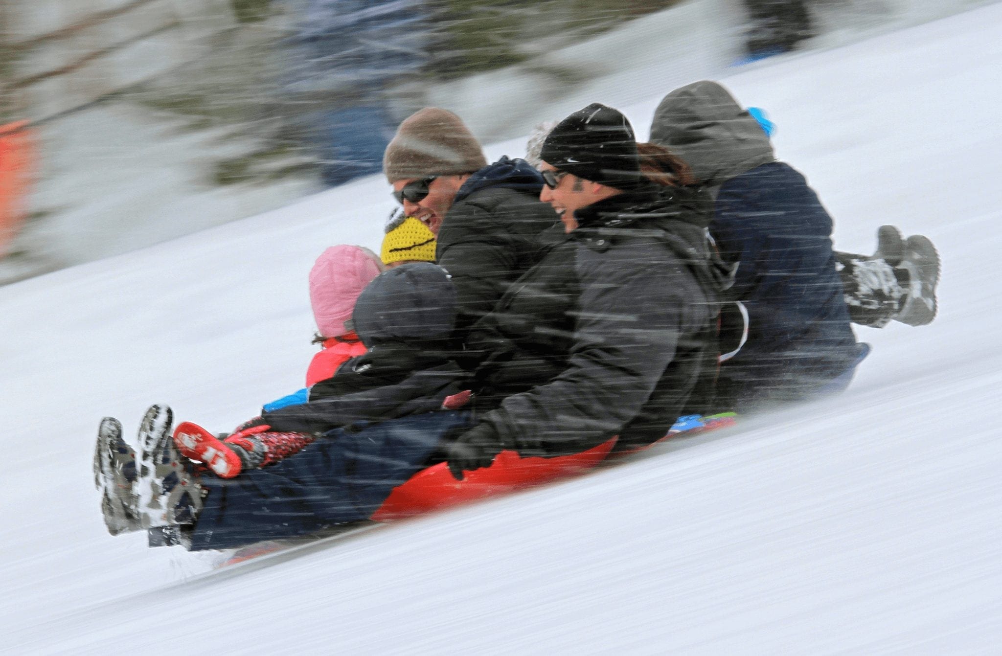 A family sledding at Carter Park. Breckenridge Spring Guide.