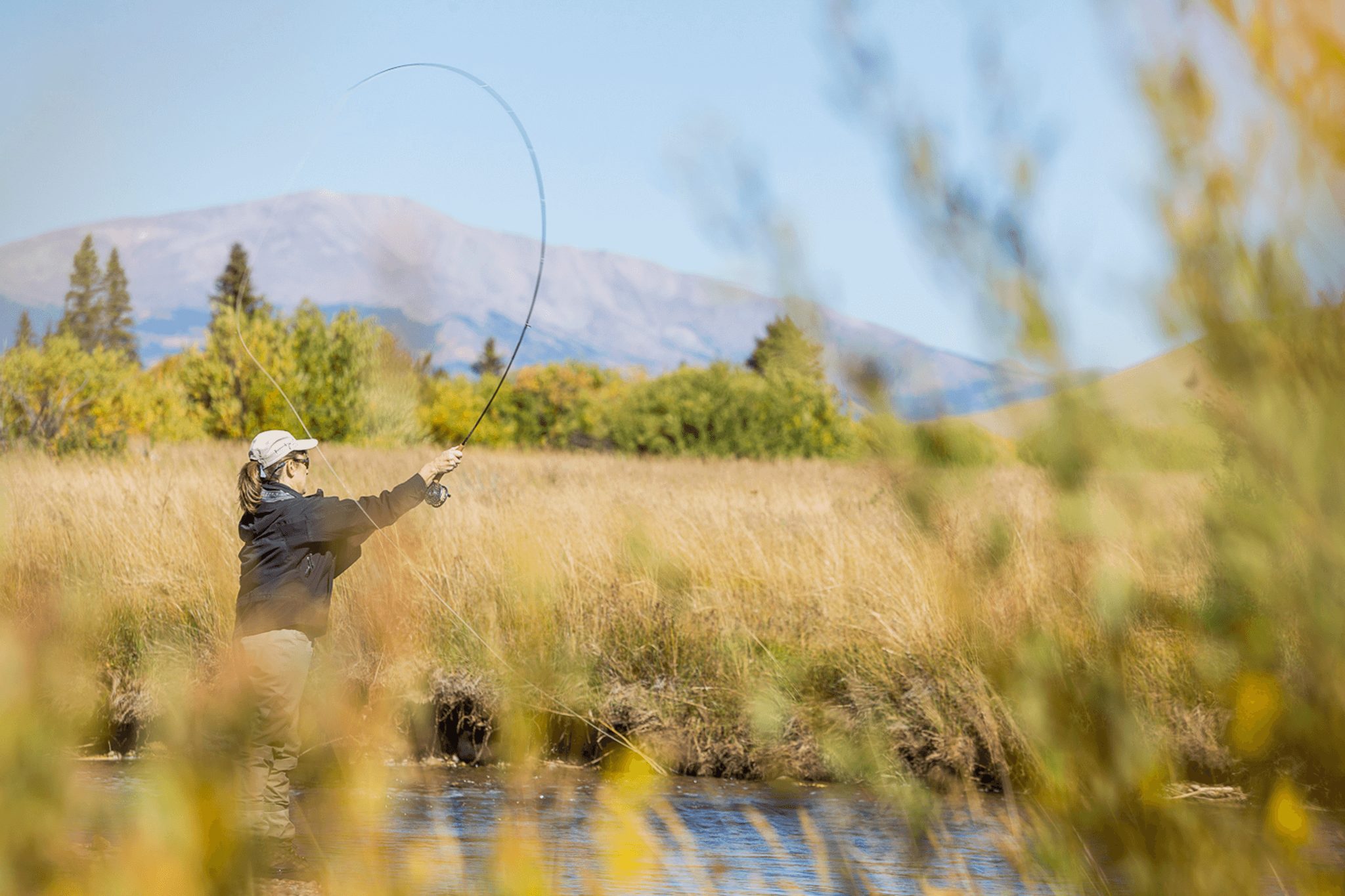 A woman casting her line while fly fishing in the Blue River