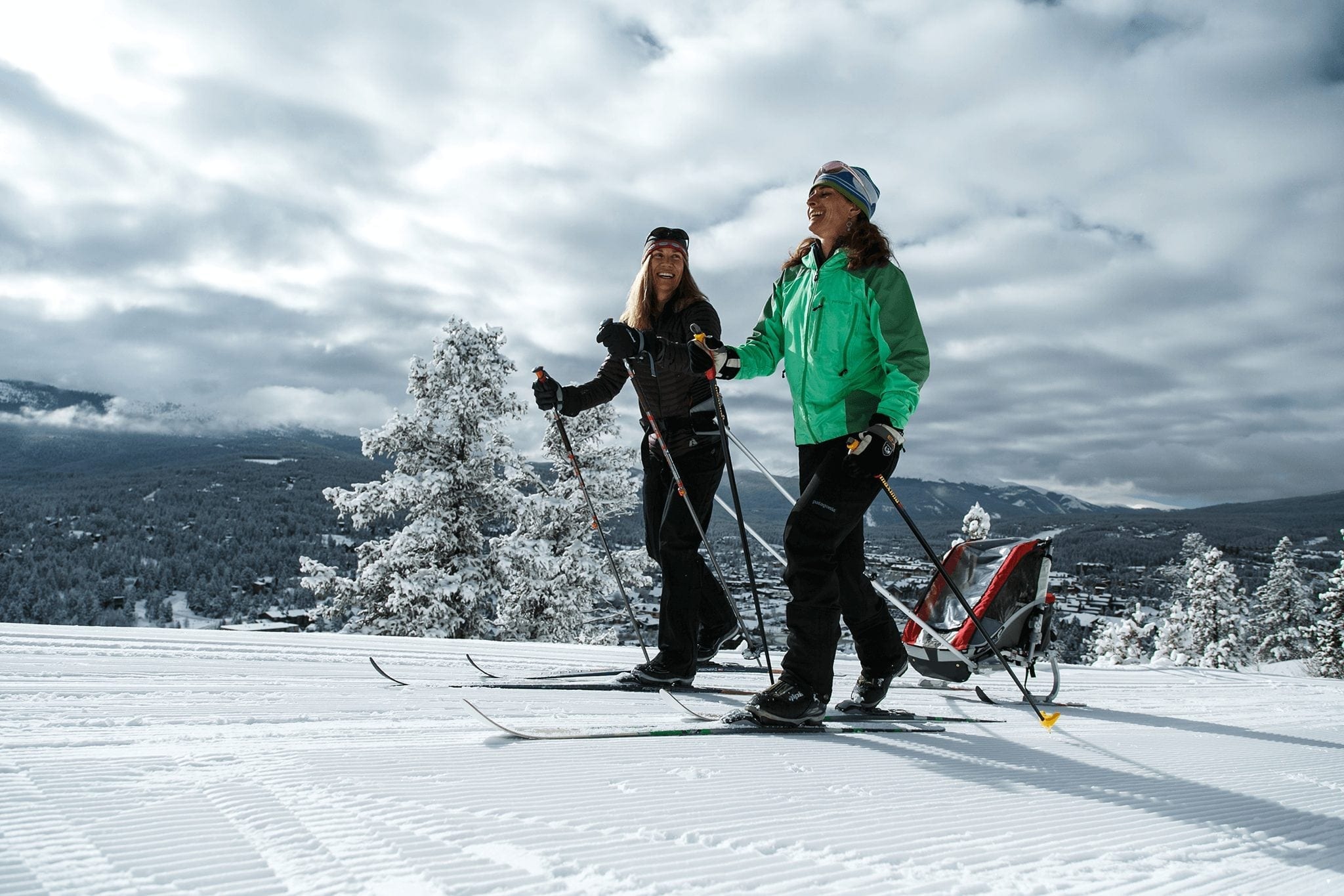 Two female cross country skiers enjoying their exercise.
