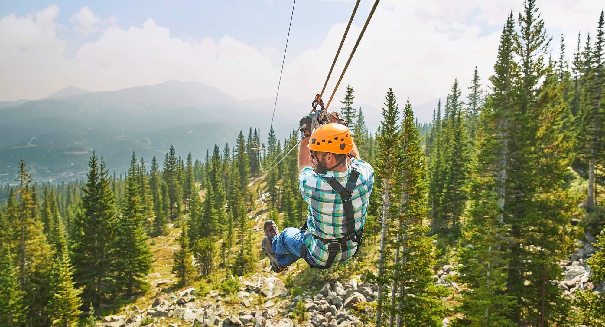 A man ziplining on Breckenridge Ski Resort as part of Epic Discovery.