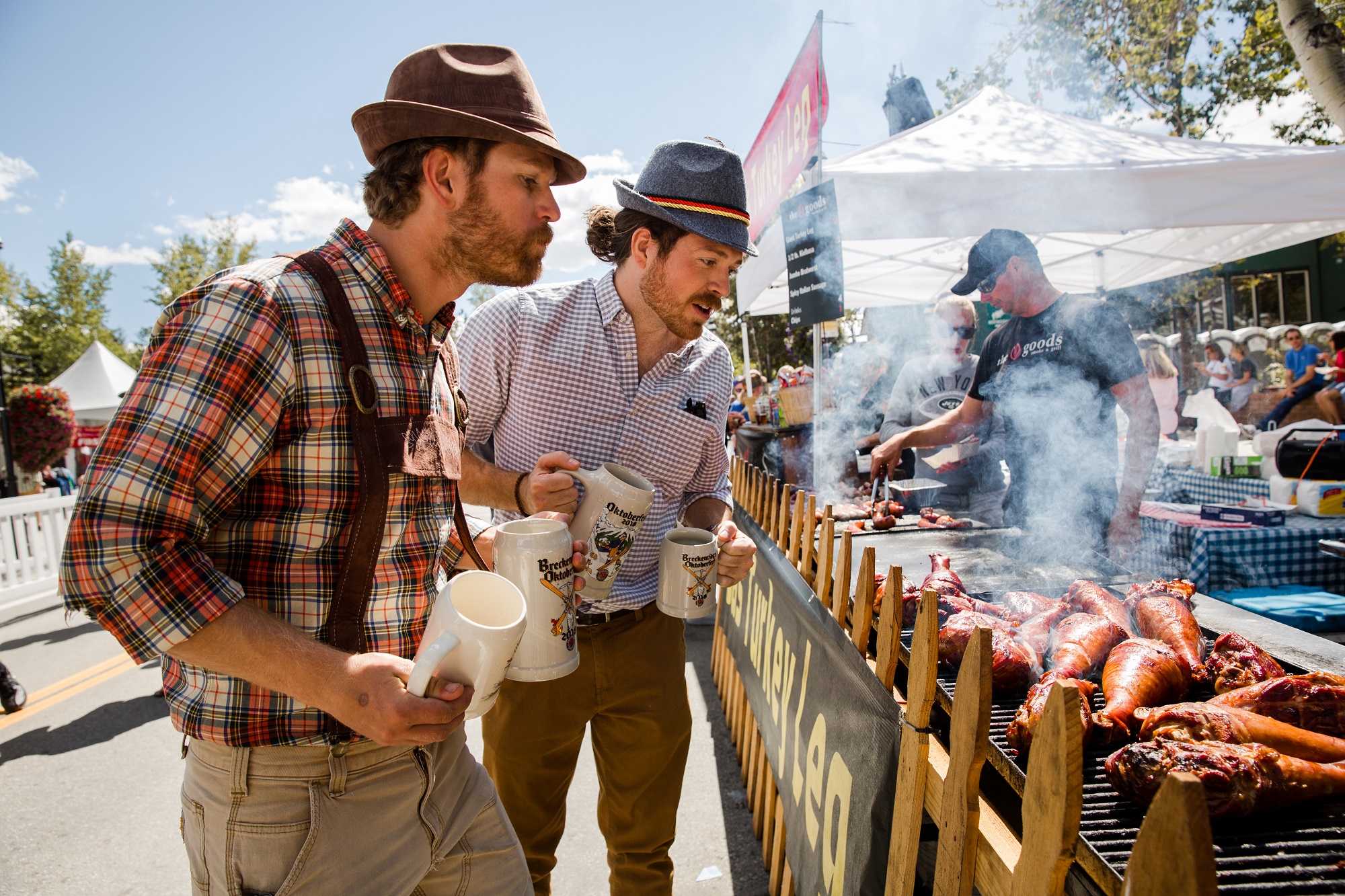 Men holding beer steins and eyeing turkey legs at Oktoberfest in Breckenridge